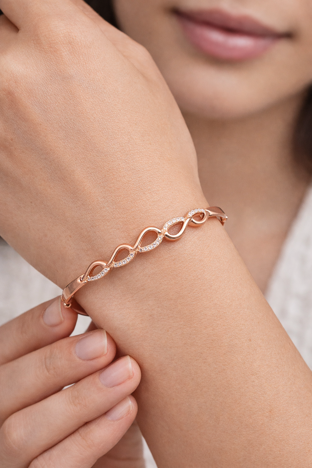 Rose gold plated sterling silver hinged bangle featuring a modern pave-set cubic zirconia wave design."